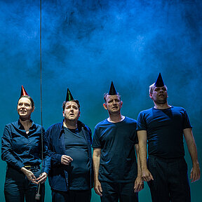 Fiffy (Franziska Werner), Zoe (Julia Friede), Tristan (Gerrit Frers), Dennis (Klaas Schramm) und Nico (Hagen Bähr) stehen frontal in einer Reihe. Sie haben bunte Partyhüte auf dem Kopf, hinter ihnen Bühnennebel.