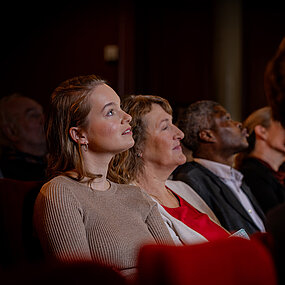 Gäste sitzen im Zuschauerraum des Großen Hauses